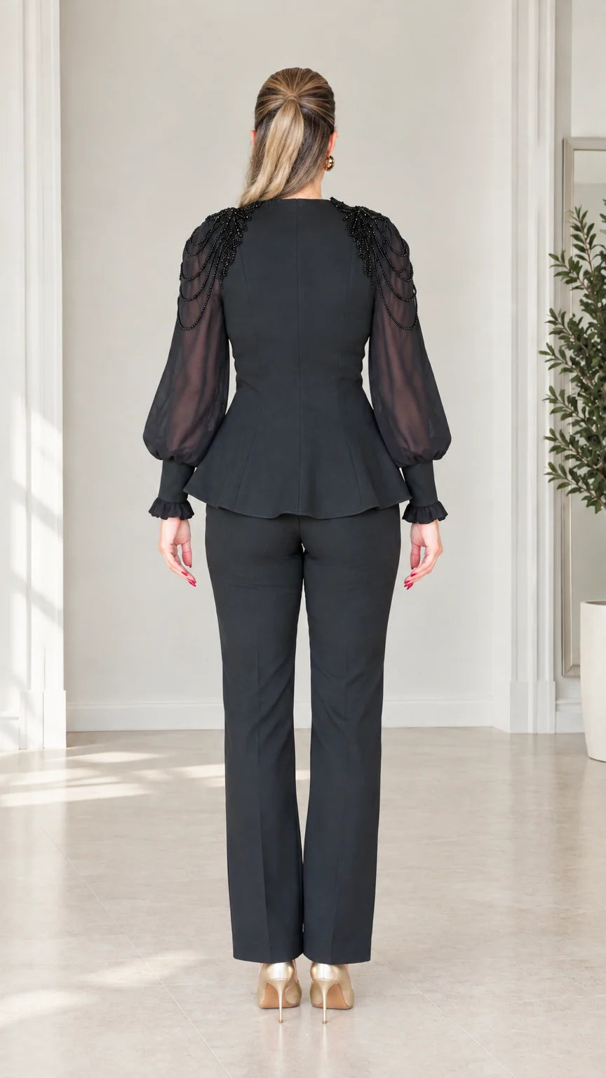 Back view of woman wearing tailored black peplum top and matching trousers