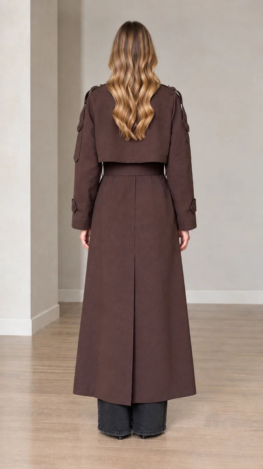 Back view of woman wearing belted brown long trench coat with storm flap