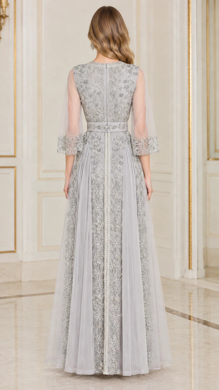 Back full-length view of silver grey embellished evening gown with sheer sleeves