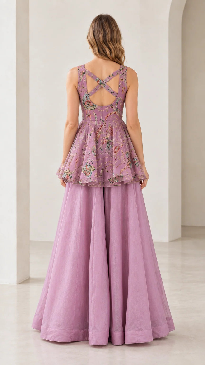 Back view of model showing strappy cross-back cutout detail on lilac peplum set