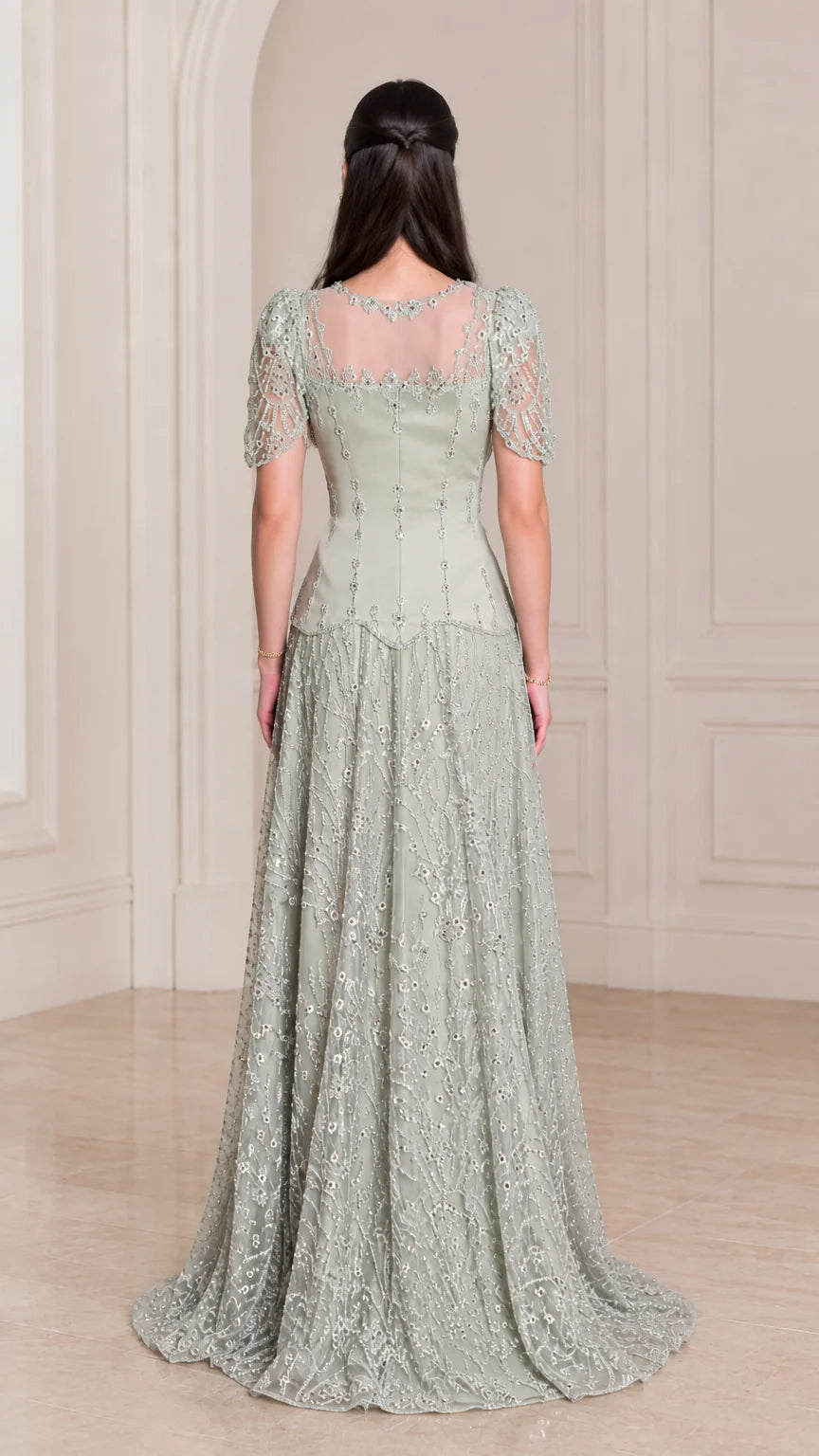 Back view of model wearing Sage Green beaded evening gown with illusion back