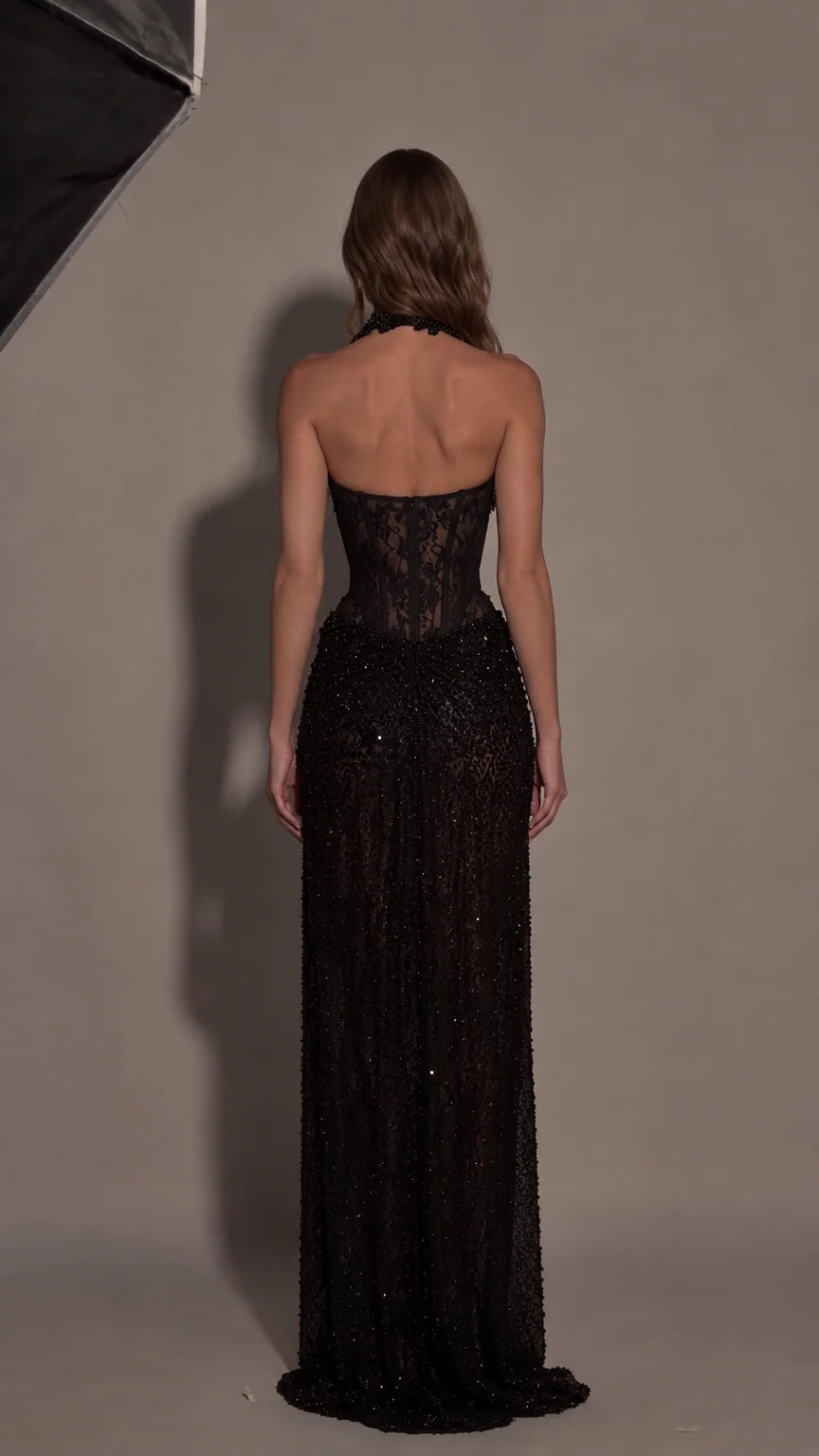 Back view of black halter corset maxi dress highlighting open back design