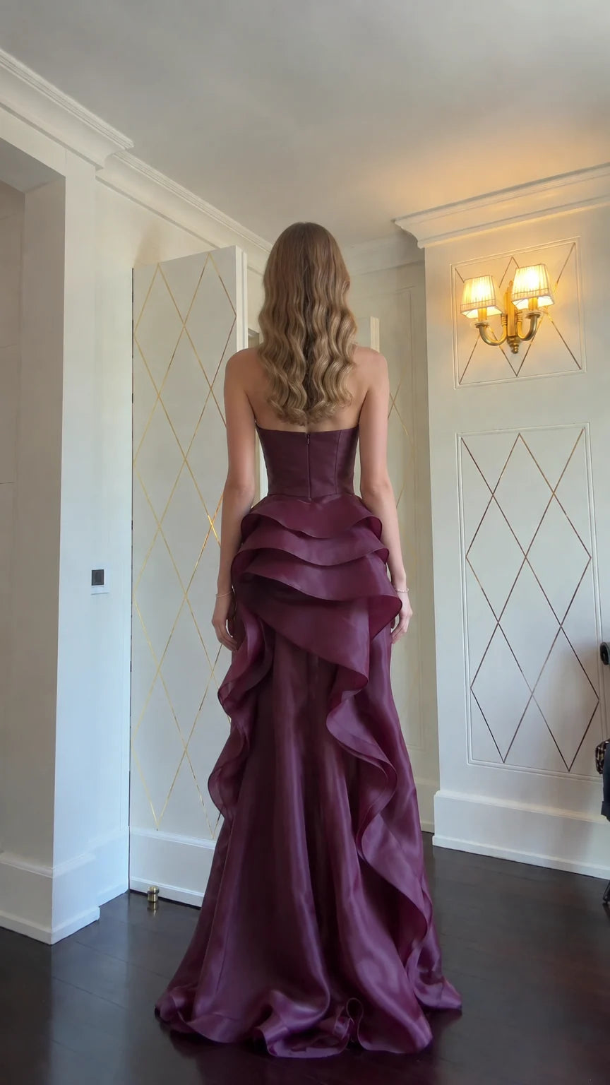 Back view of model in Burgundy strapless tiered ruffle formal gown