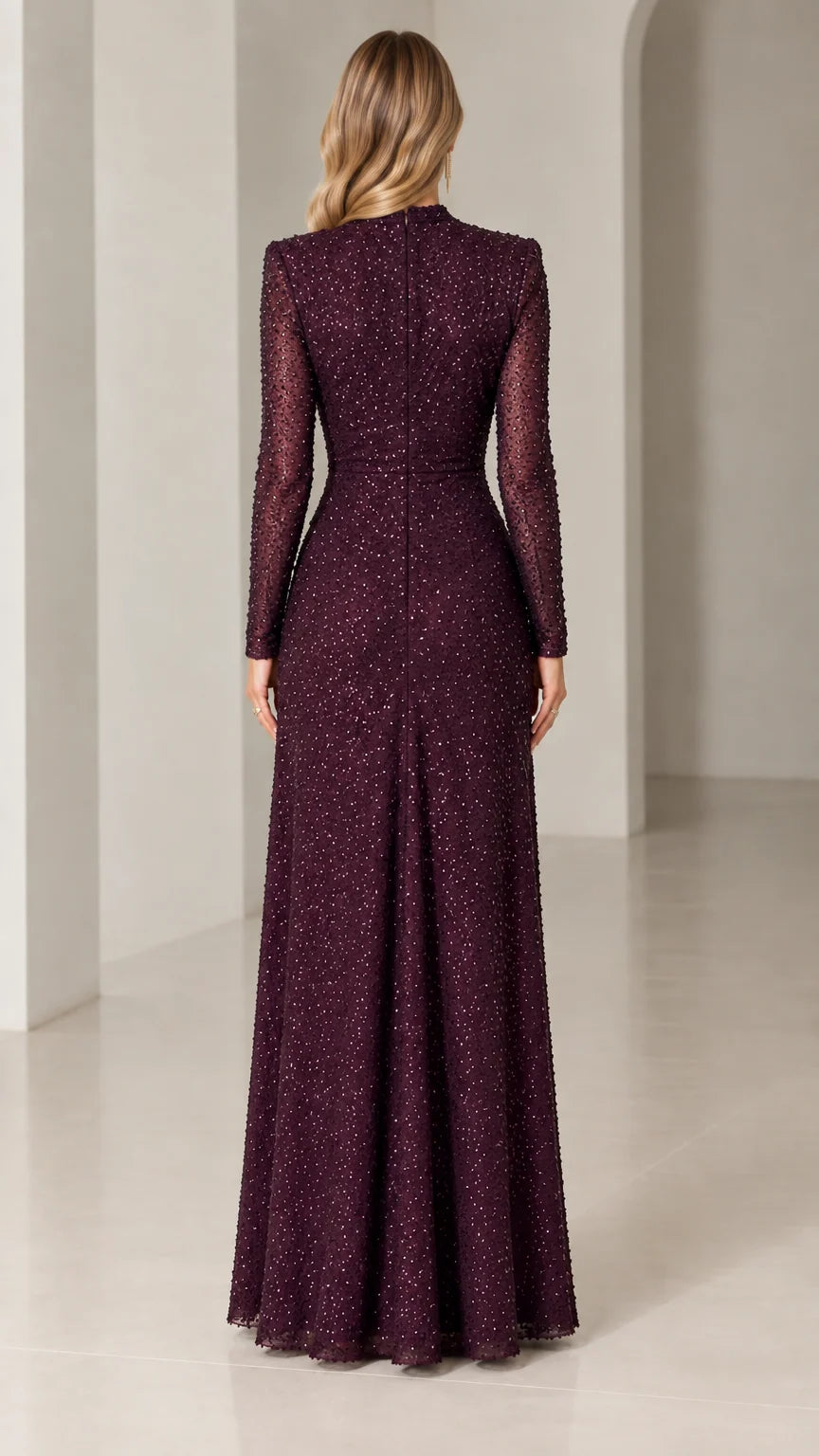 Back view of woman wearing burgundy sequined long-sleeve evening gown