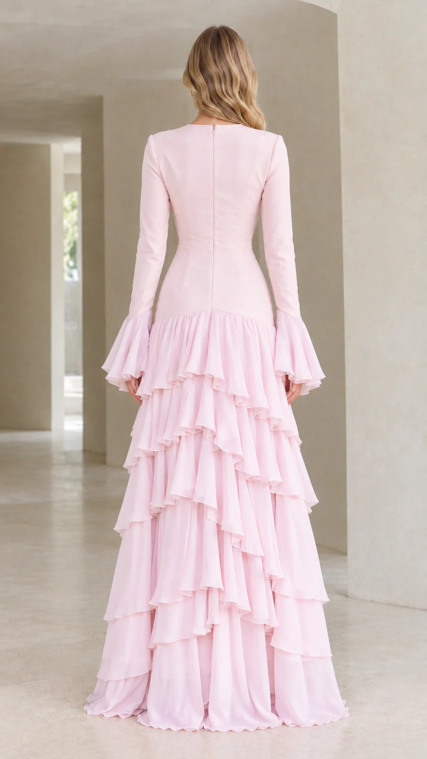 Back view of woman wearing blush pink long sleeve formal evening gown