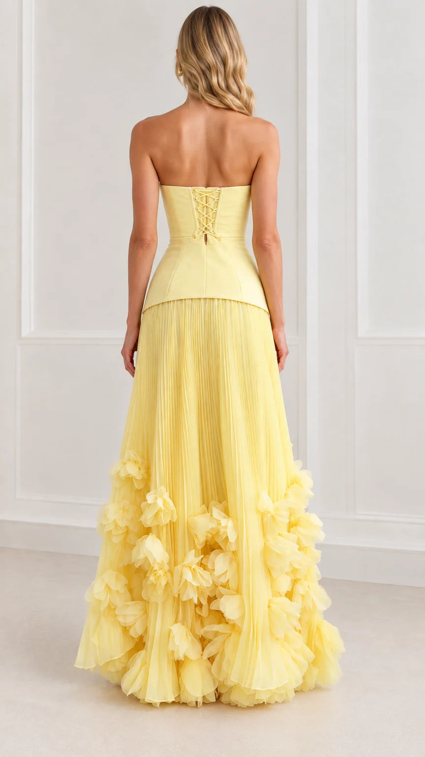 Back view of model wearing yellow strapless corset maxi dress showcasing lace-up tie closure