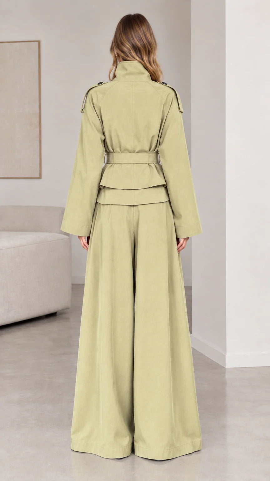 Back view of woman wearing sage green belted trench jacket and wide palazzo pants
