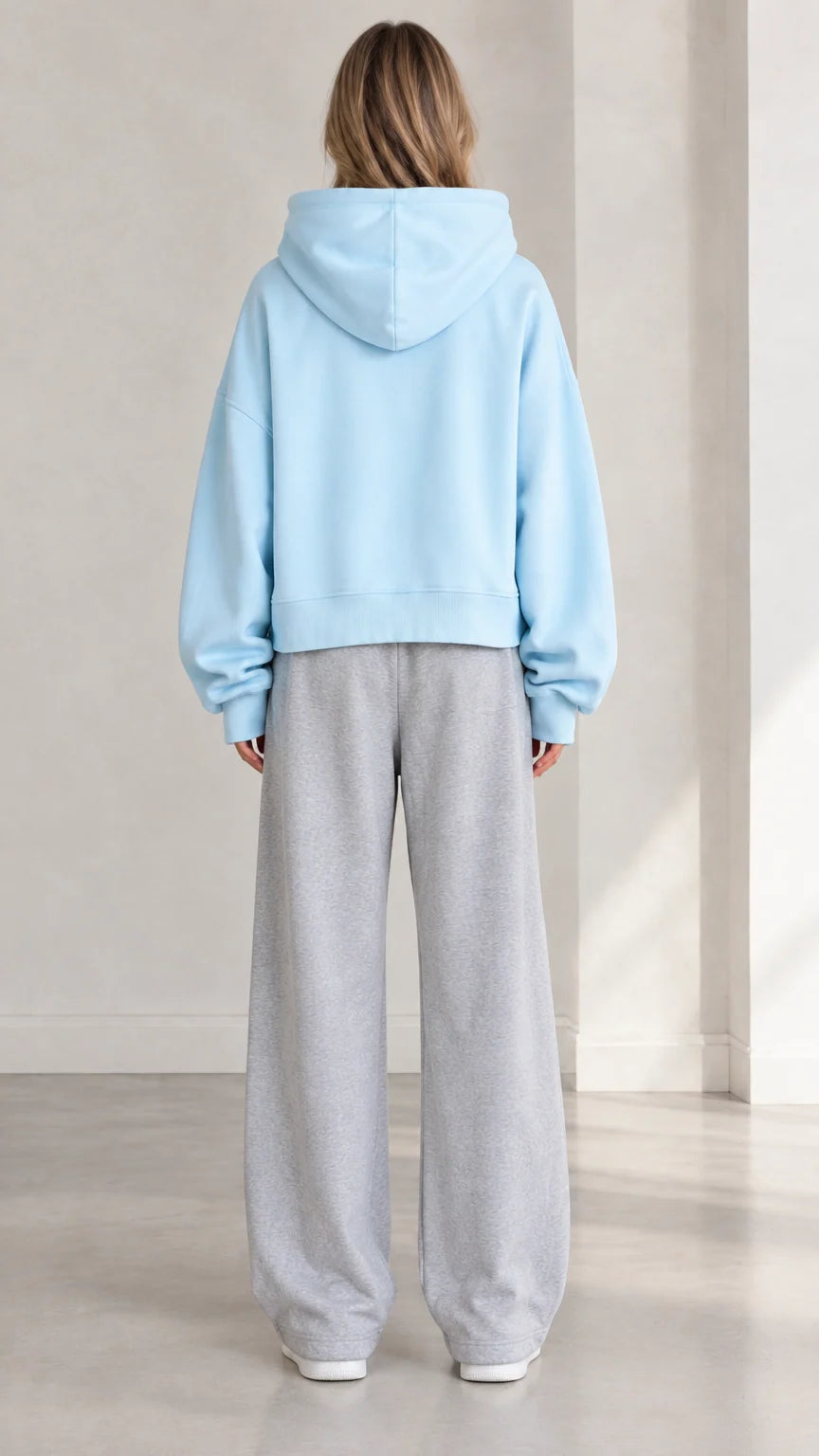 Back view of woman wearing Light Blue cropped hoodie showing relaxed fit and hood