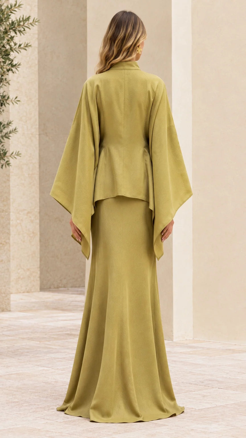 Back view of woman in olive green floor-length cape dress