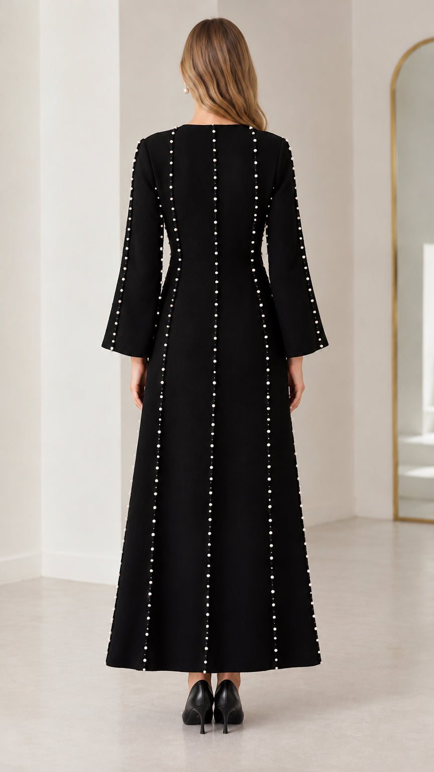 Back view of black long sleeve modest gown with vertical pearl lines