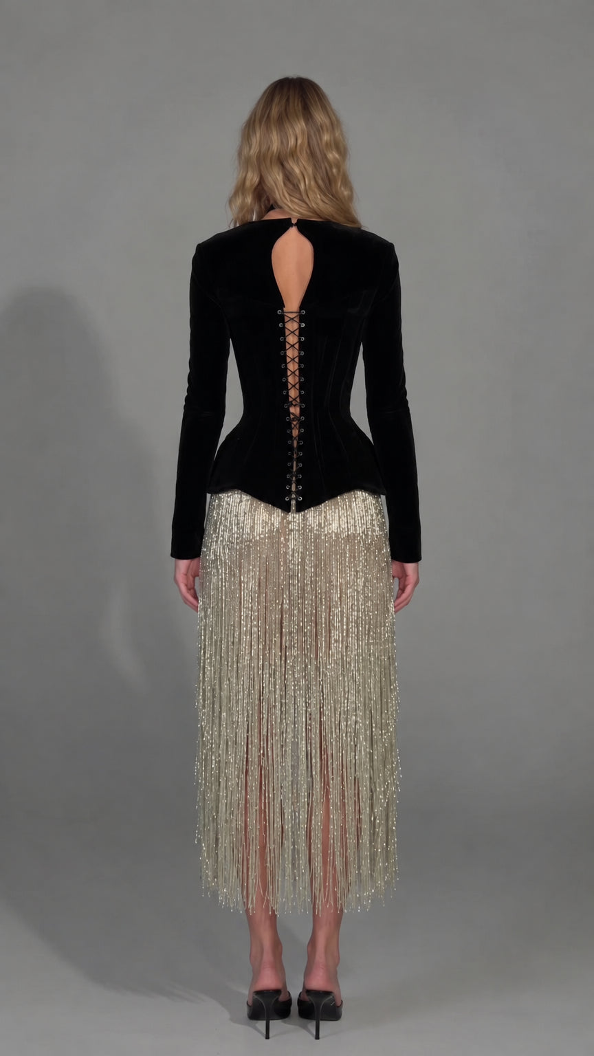 Back view of model in black velvet dress showing keyhole cutout and corset lace-up detail