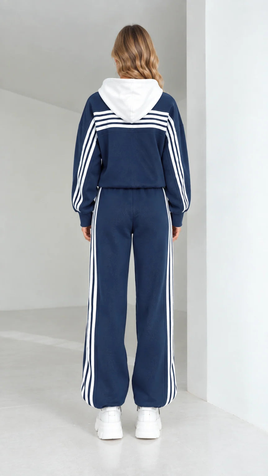 Back full view of navy blue hooded tracksuit showing contrast stripes across shoulders and down legs