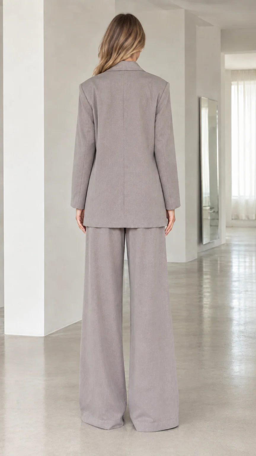 Back view of women's taupe grey tailored suit jacket and wide-leg pants