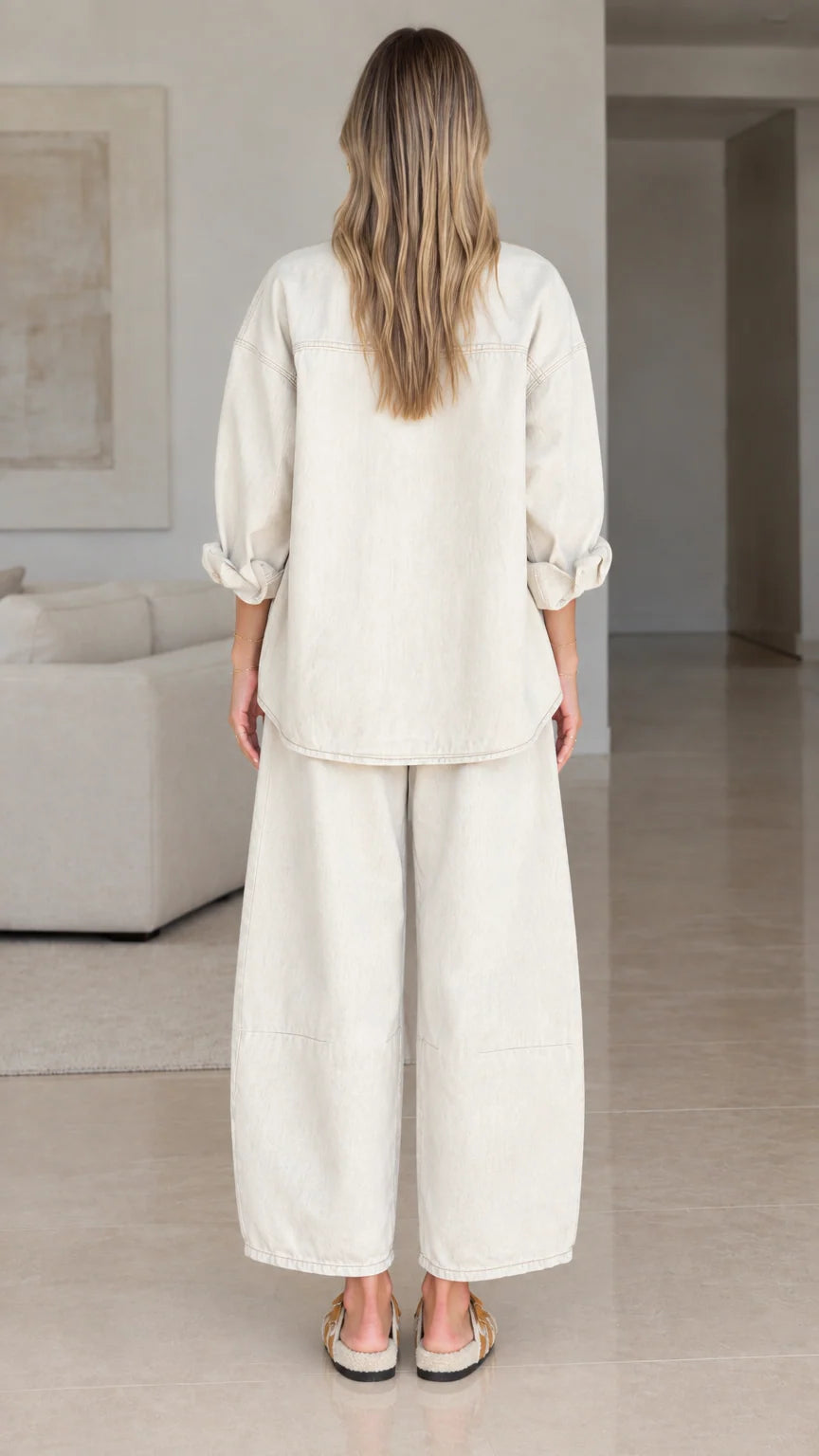 Back view of women's relaxed fit matching shirt and pants set in cream
