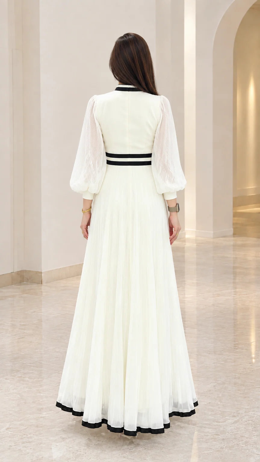 Back view of white pleated floor-length dress showing fitted waist detail
