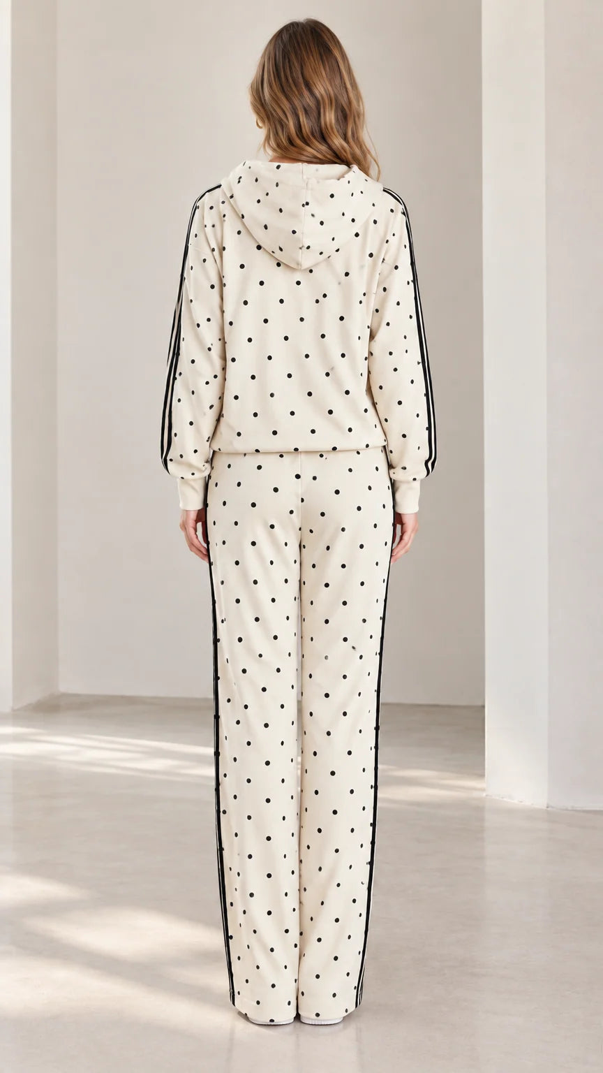 Back view of model wearing cream polka dot hooded two-piece loungewear set