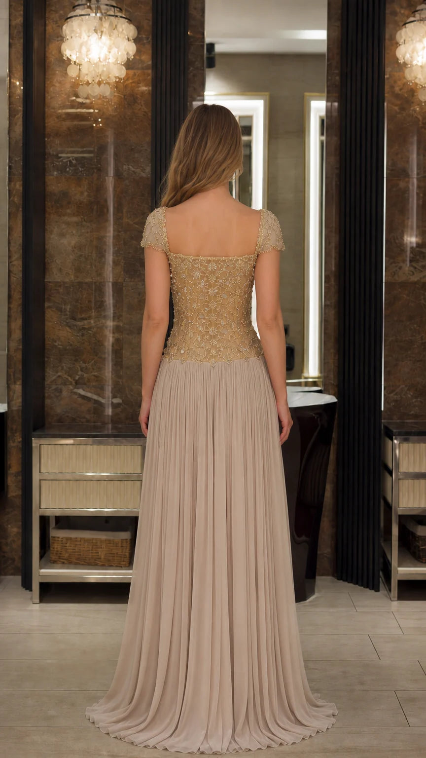 Back view of model wearing the Champagne beaded illusion back pleated formal dress