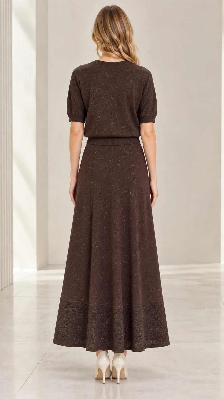Back view of model in coffee brown short sleeve knit top and flowing maxi skirt
