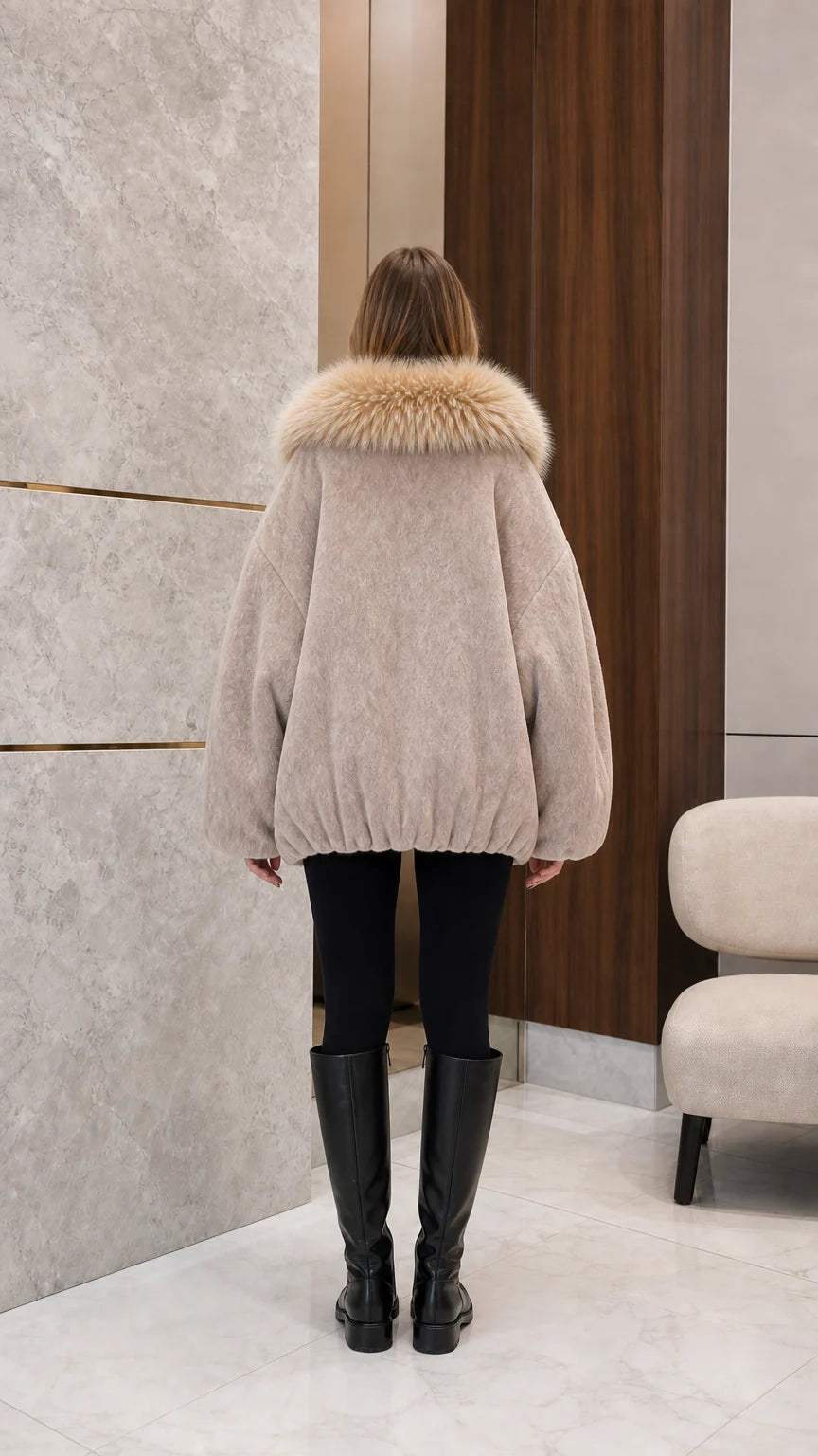 Back view of woman wearing beige fleece cocoon coat showing relaxed bubble hem