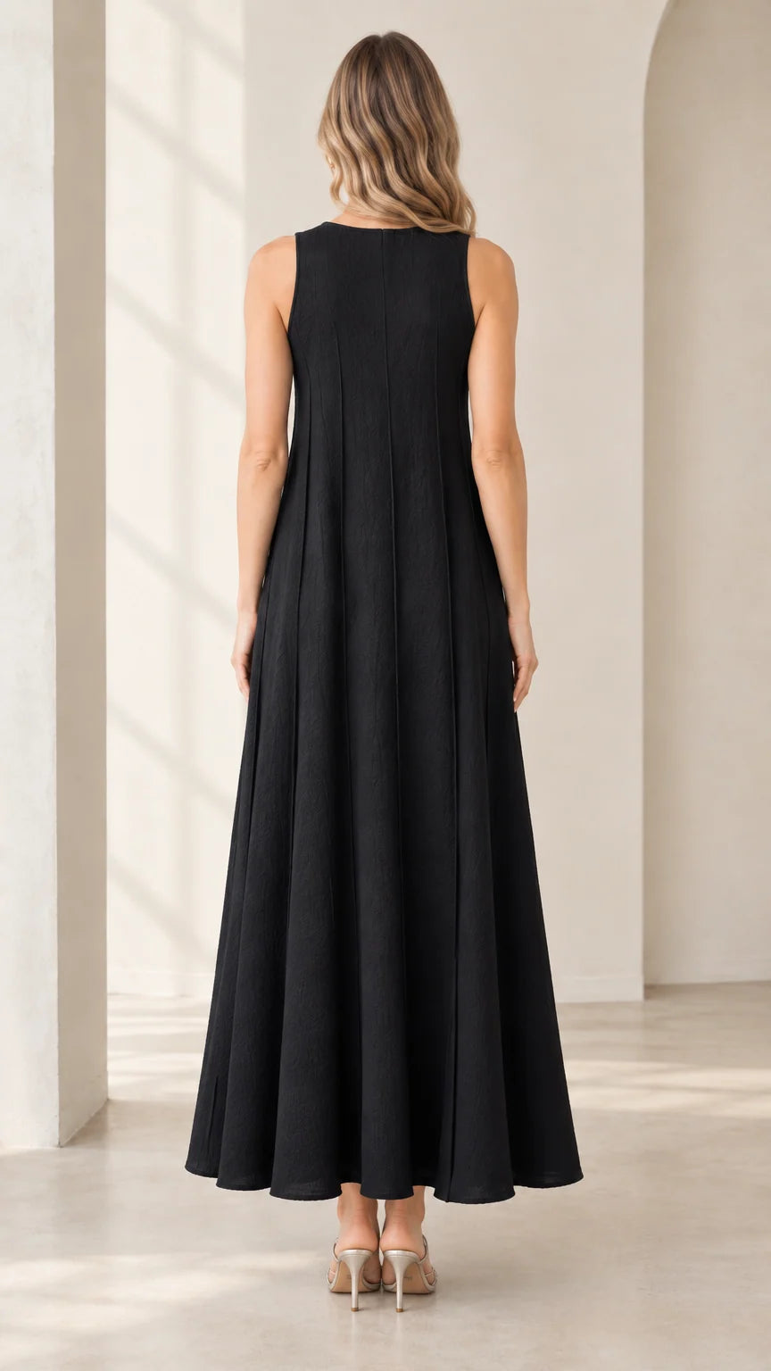 Back full-length view of woman wearing black sleeveless maxi dress showing vertical seam detailing