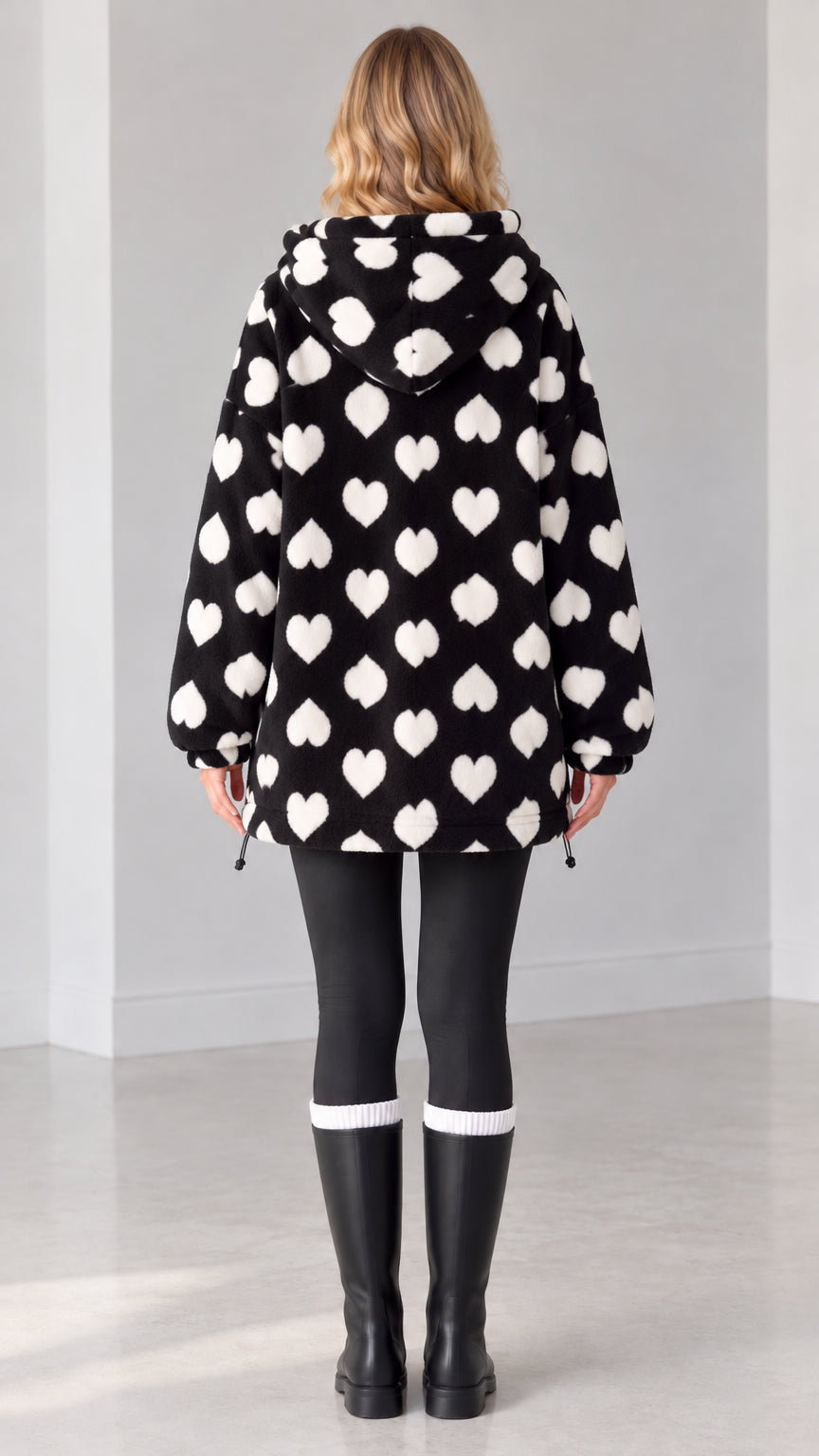 Back view of black hooded heart print fleece jacket on model