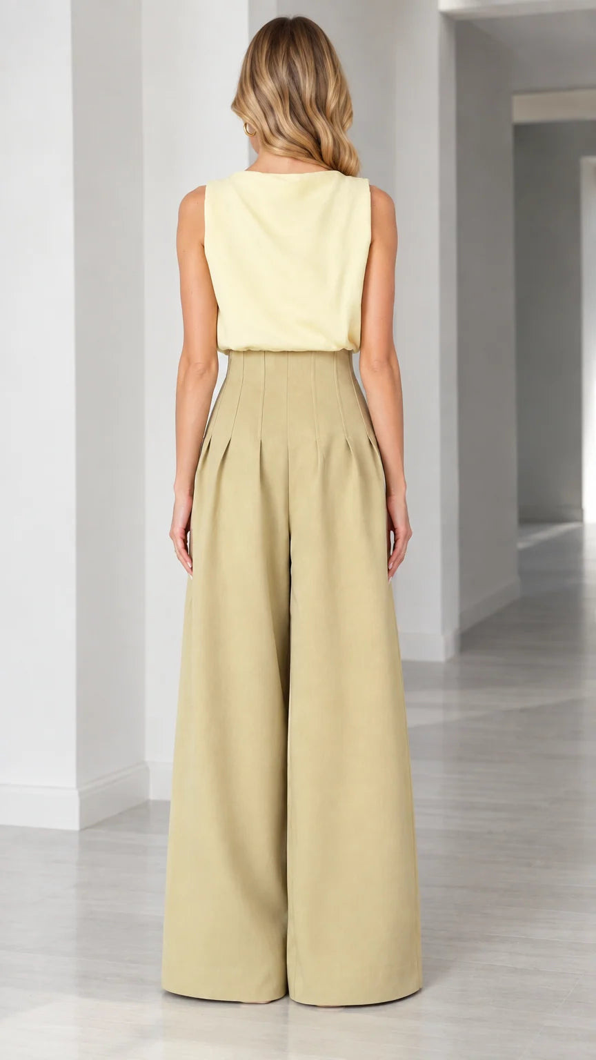 Back view of model showing clean sleeveless cut and flowing wide-leg trousers