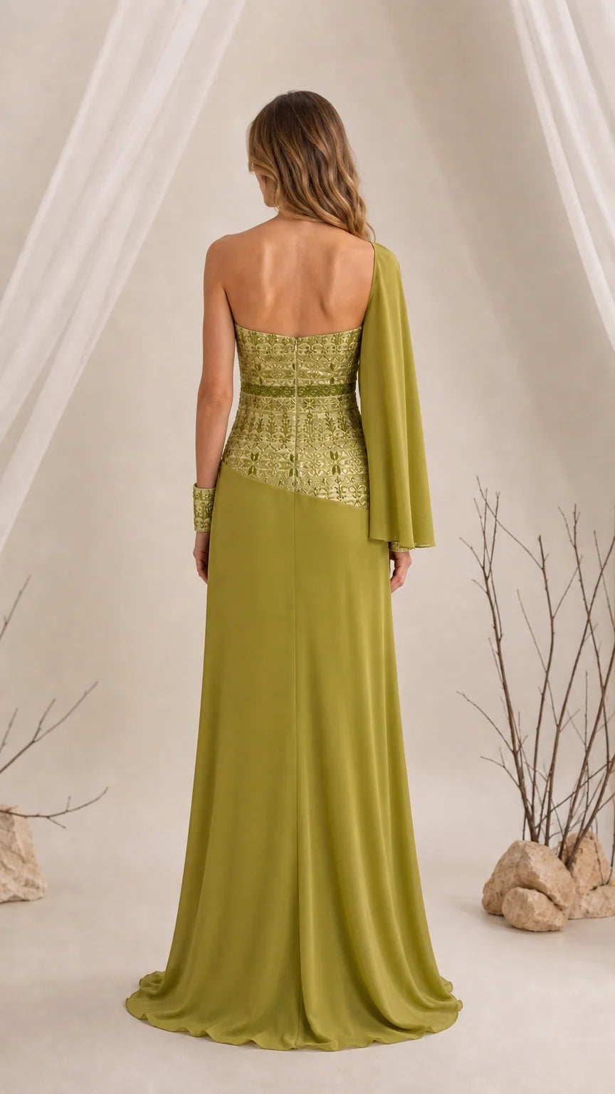 Back view of olive green strapless evening gown showing one-sided flowing cape sleeve