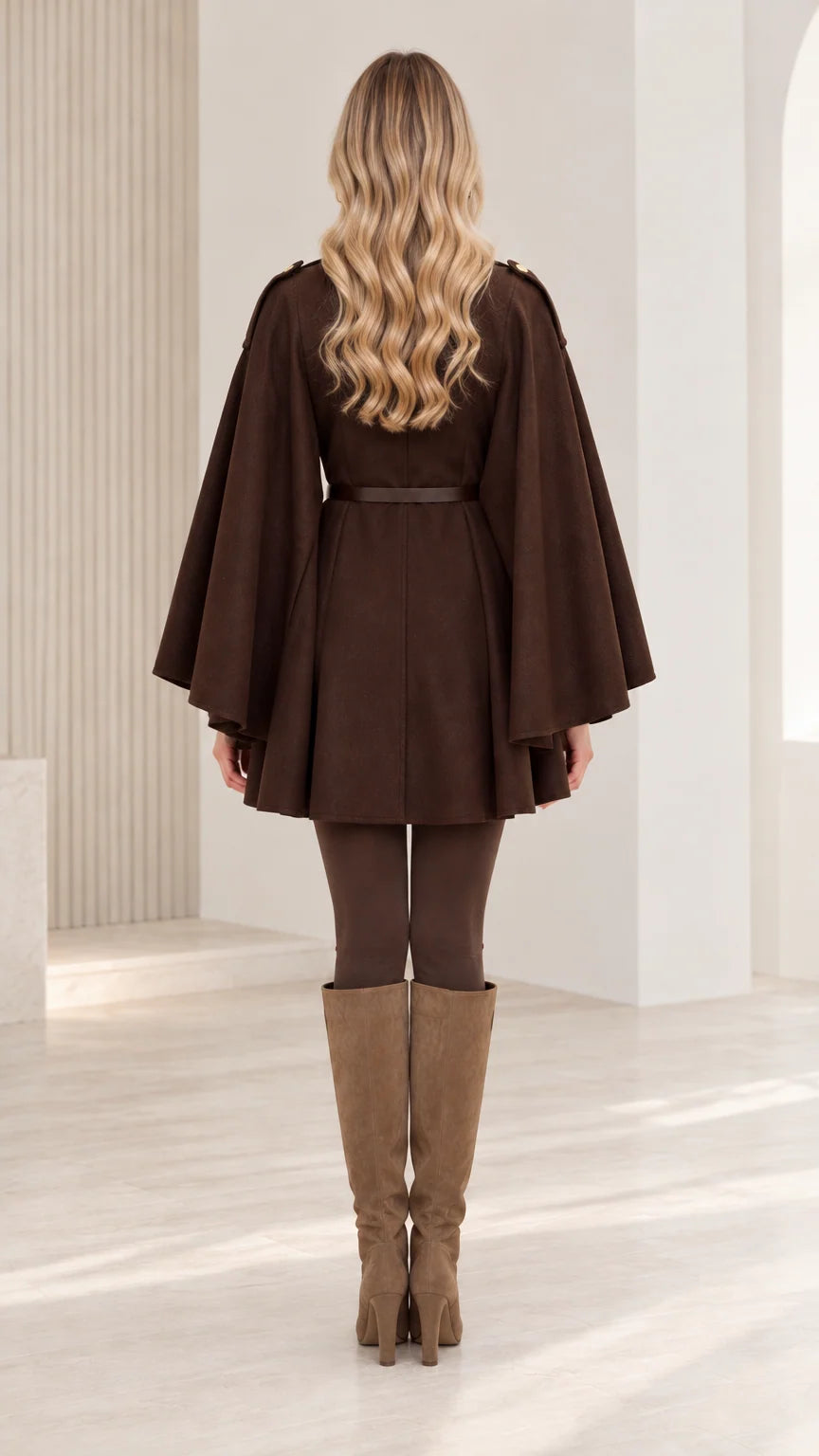 Back view of woman wearing chocolate brown belted cape coat with elegant draped design