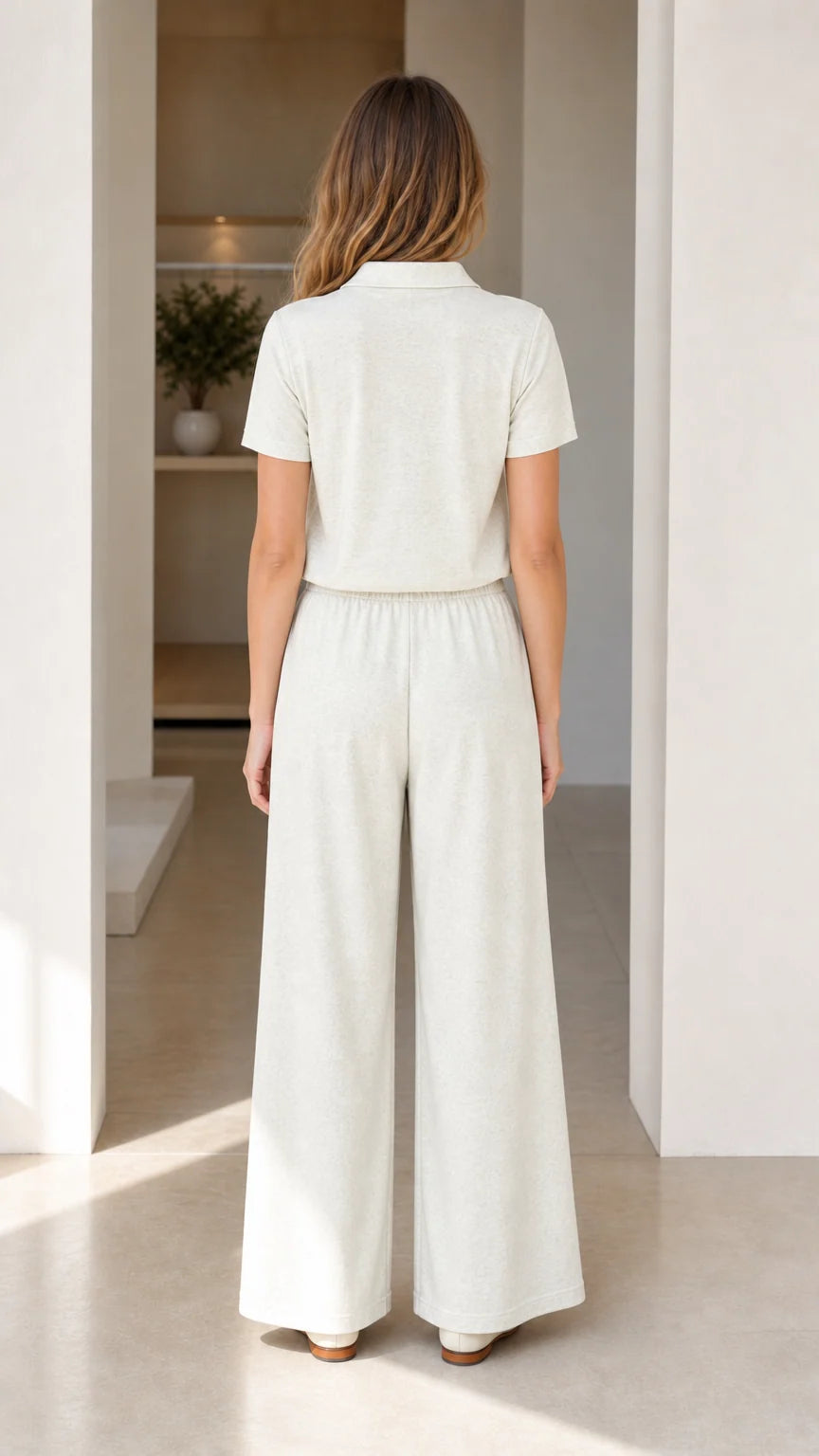 Back view of woman wearing cream knit polo shirt and matching wide-leg pants