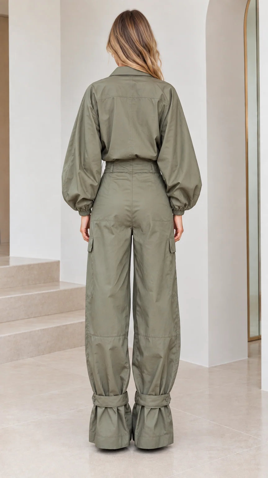 Back full view of woman wearing the olive green utility cargo jumpsuit