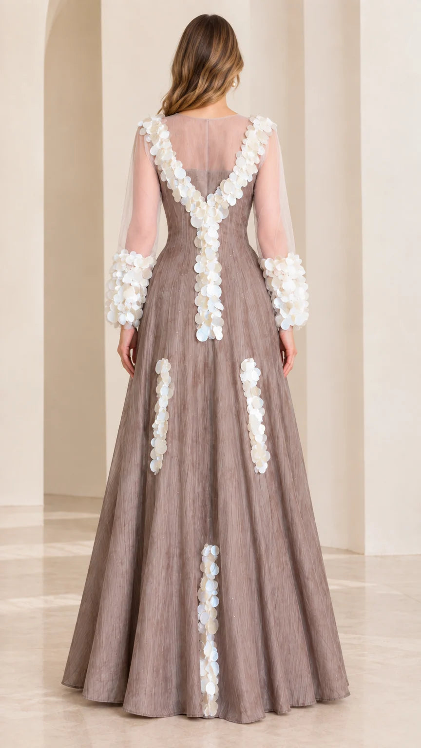 Back full-length view of taupe formal gown featuring sheer back yoke and vertical petal trims