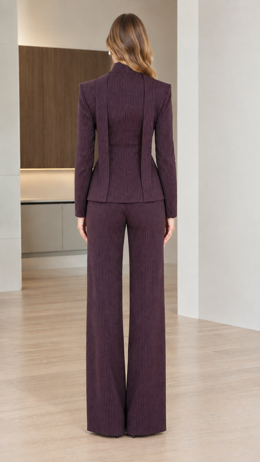 Back view of woman wearing fitted burgundy pinstripe blazer and wide leg pants