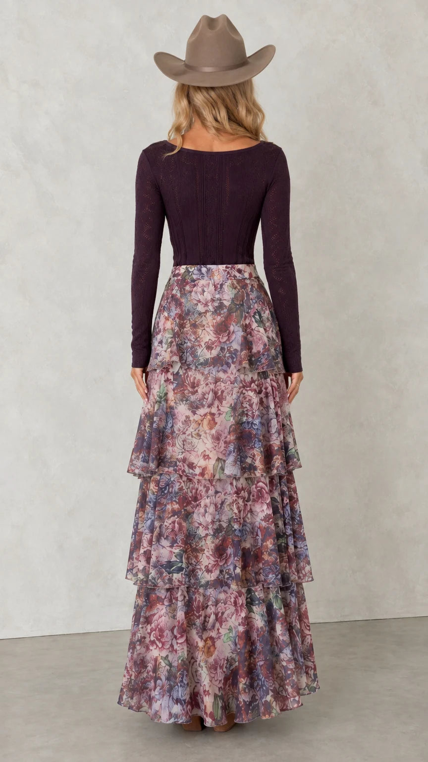 Back view of woman showing the tiered ruffle layers of floral maxi skirt