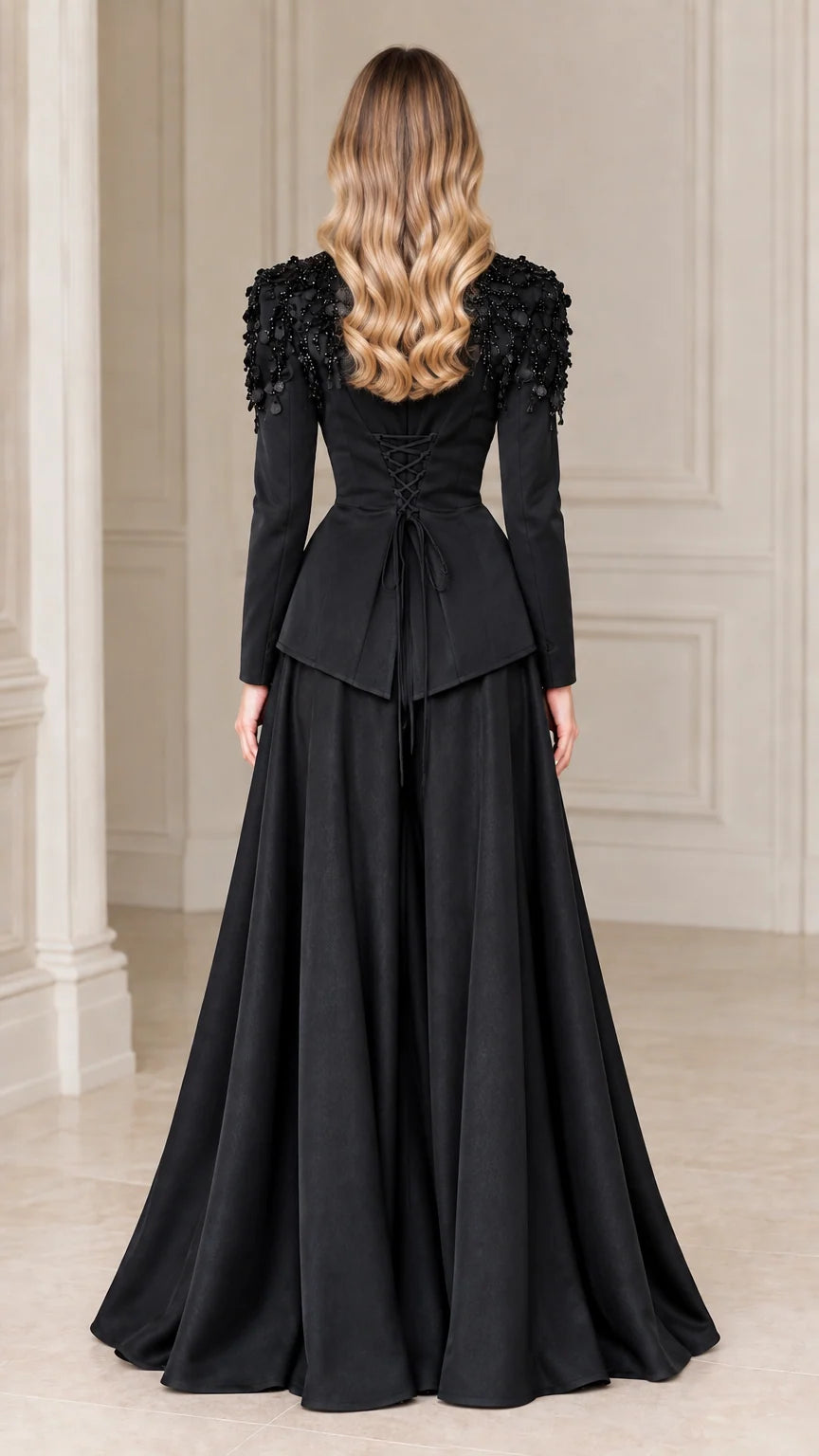 Back view of black evening blazer showing lace-up corset detail and flowing maxi skirt