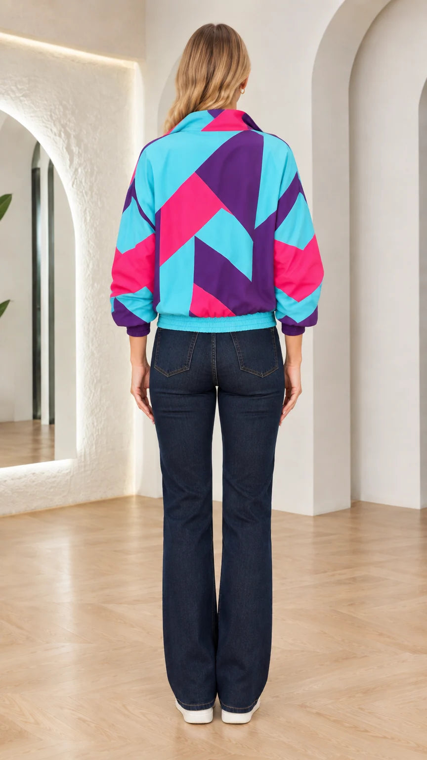 Back view of woman wearing turquoise and purple geometric windbreaker jacket