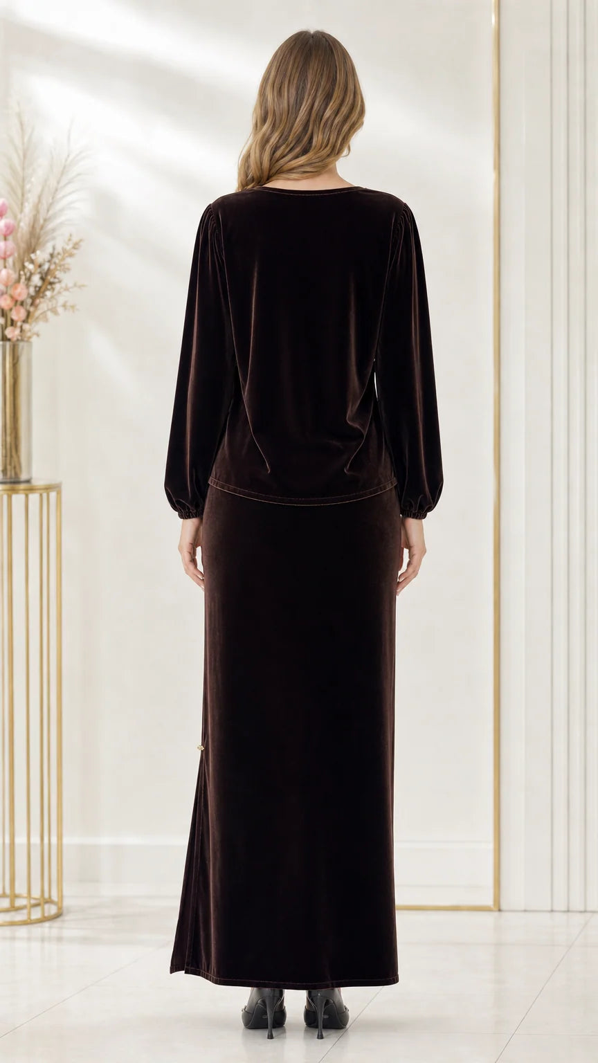 Back full-length view of woman wearing dark brown velvet long sleeve top and maxi skirt