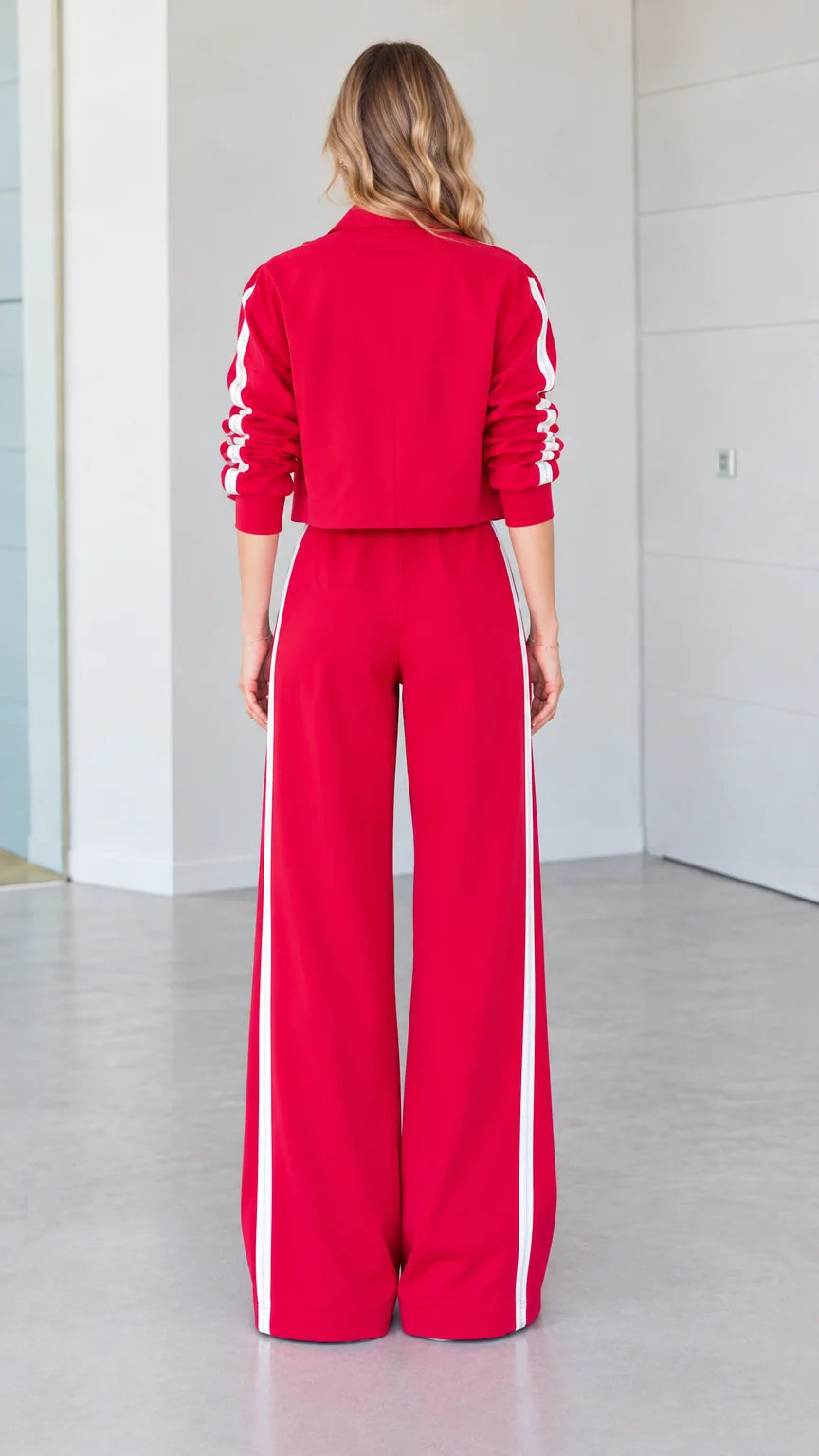 Back view of woman wearing red cropped jacket and wide-leg tracksuit pants
