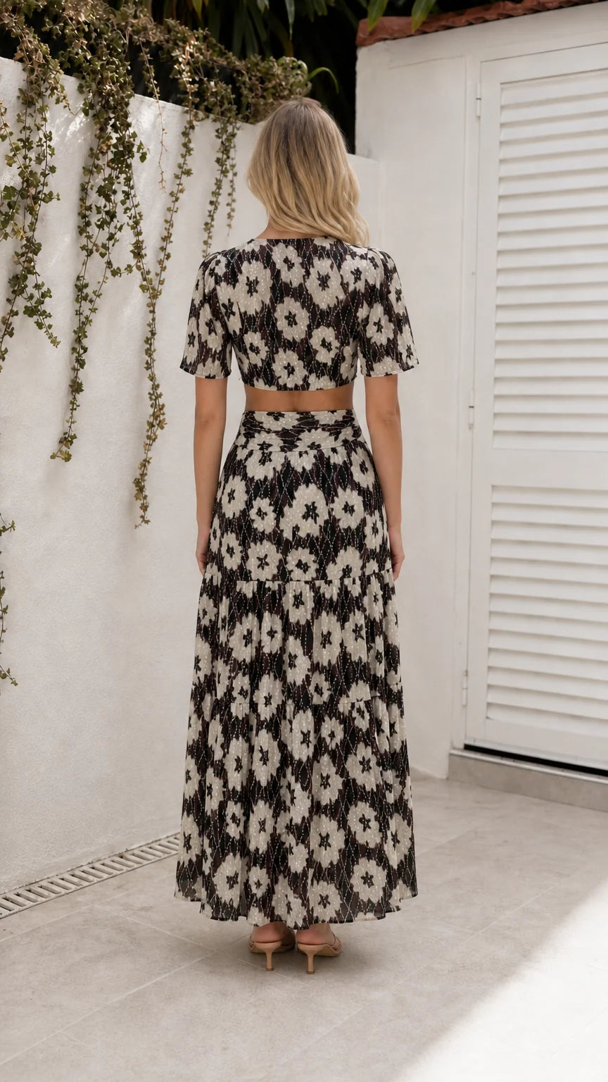 Back view of model wearing black floral cutout maxi dress
