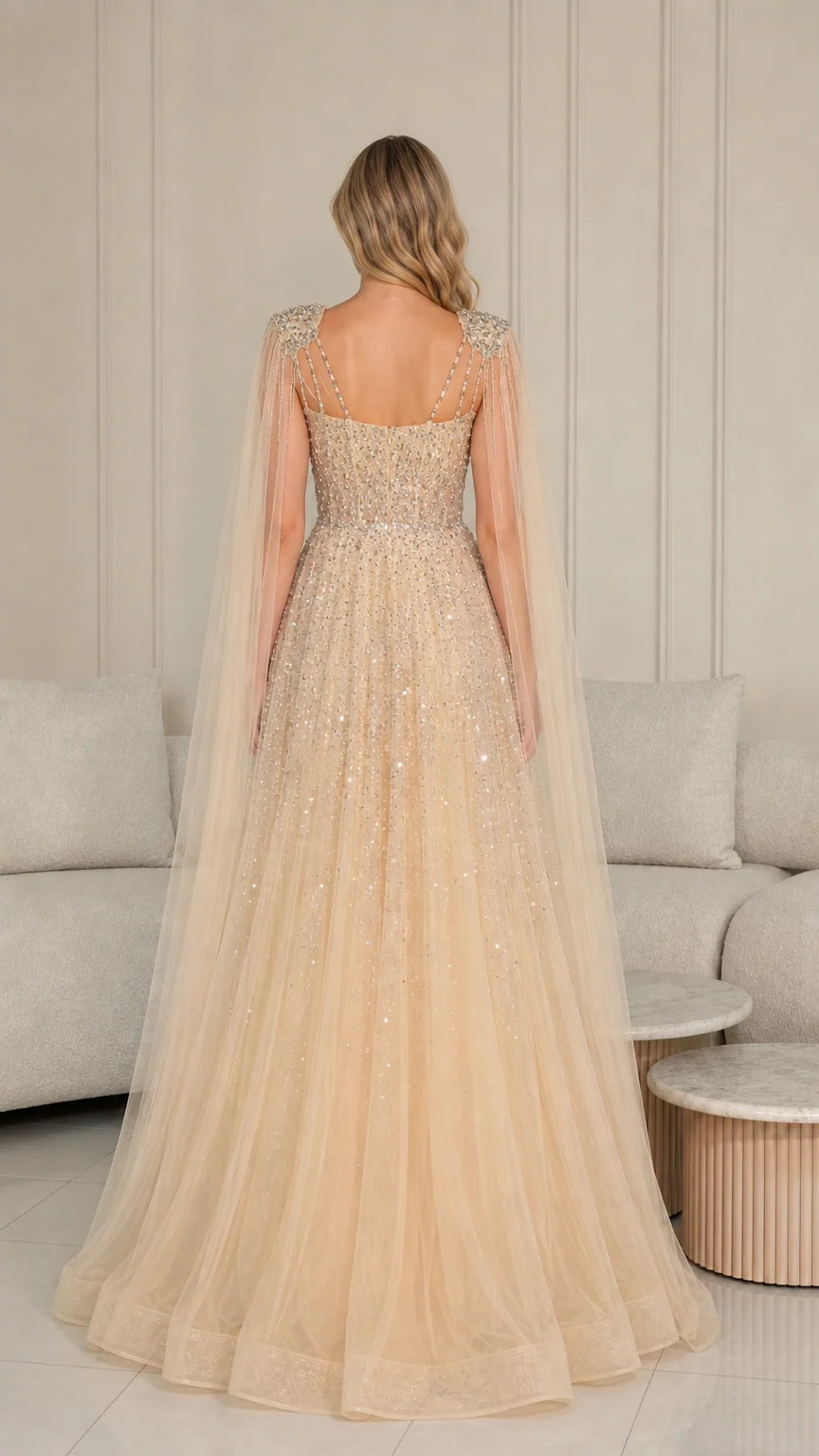Back view of champagne floor-length evening gown showing flowing tulle cape