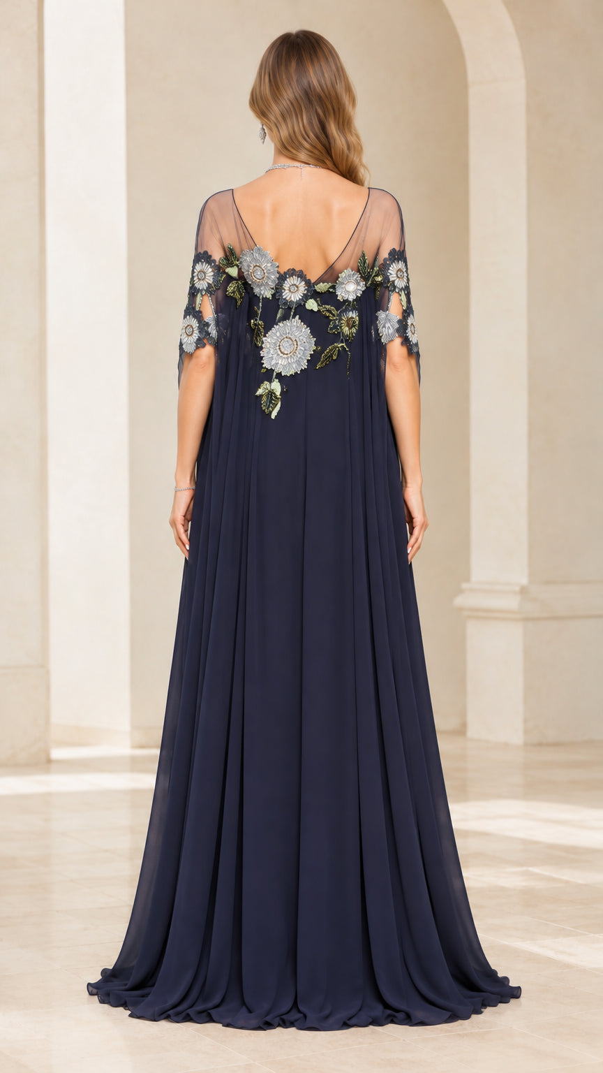 Back view of navy blue cape evening gown showing sheer embroidered back