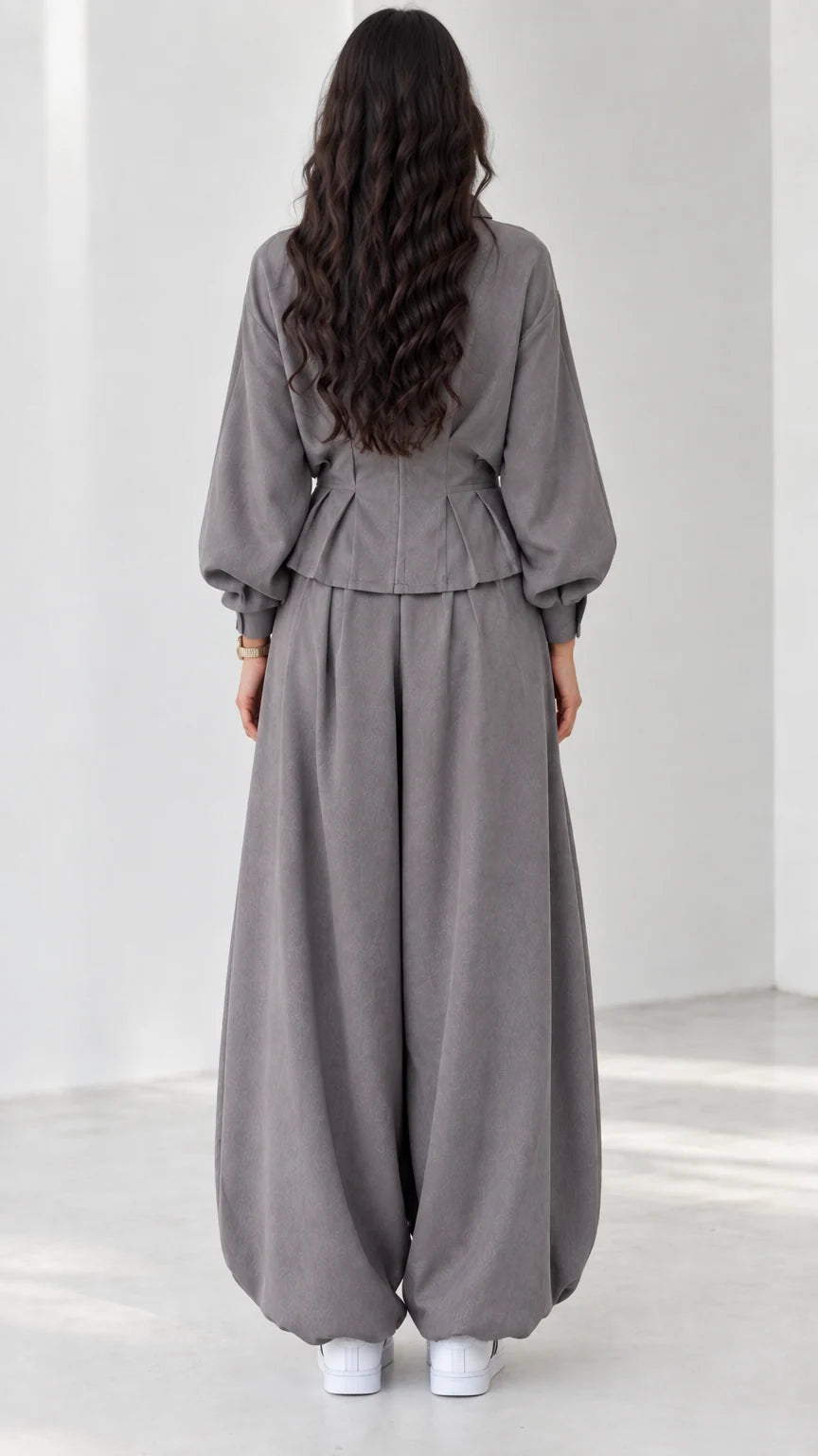 Back view of model in grey long-sleeve two-piece outfit with gathered waist and cuffs