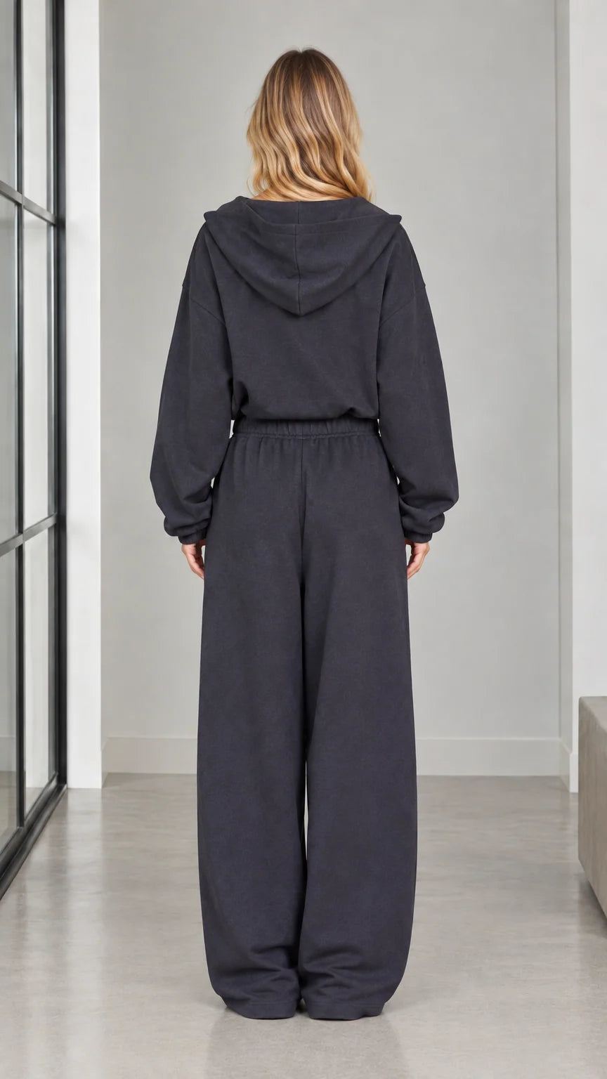 Back view of woman wearing the charcoal hooded jumpsuit with wide-leg pants