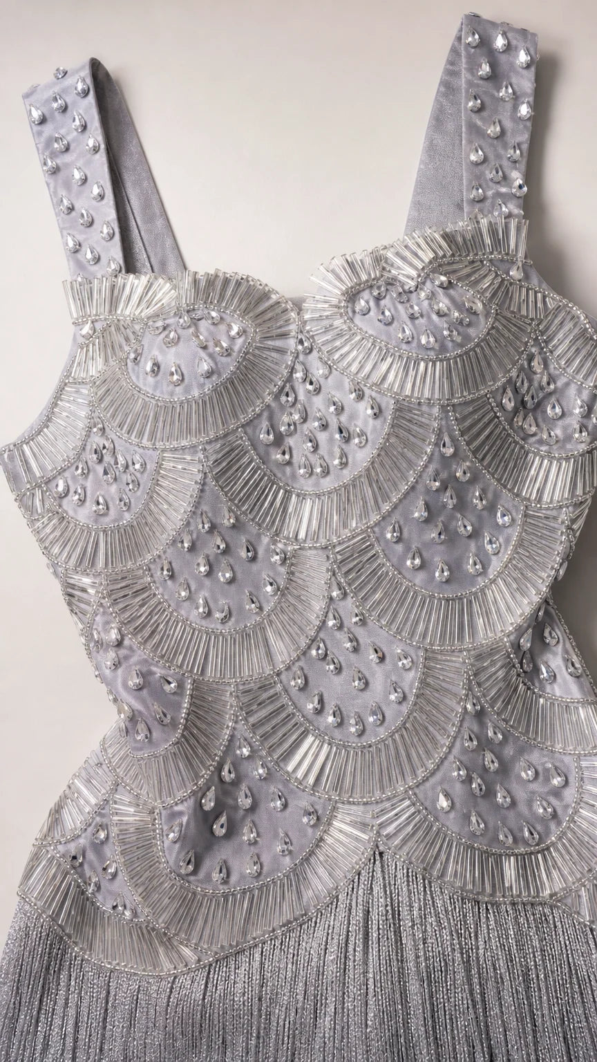 Close-up detail of ornate scallop beadwork and sequin embellishments on silver bodice