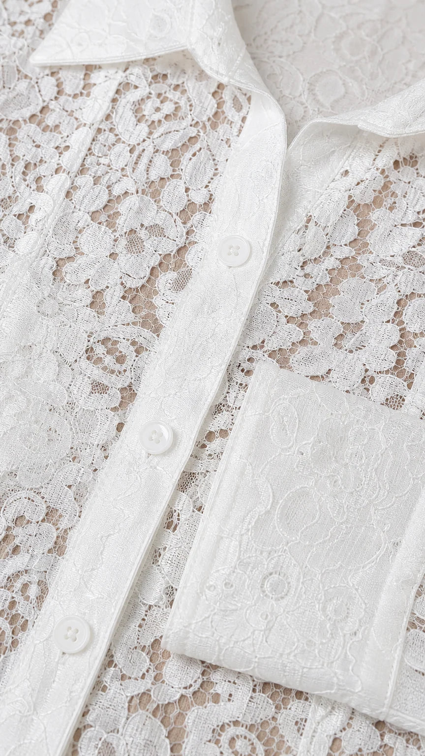 Close-up detail of white floral lace fabric and button placket