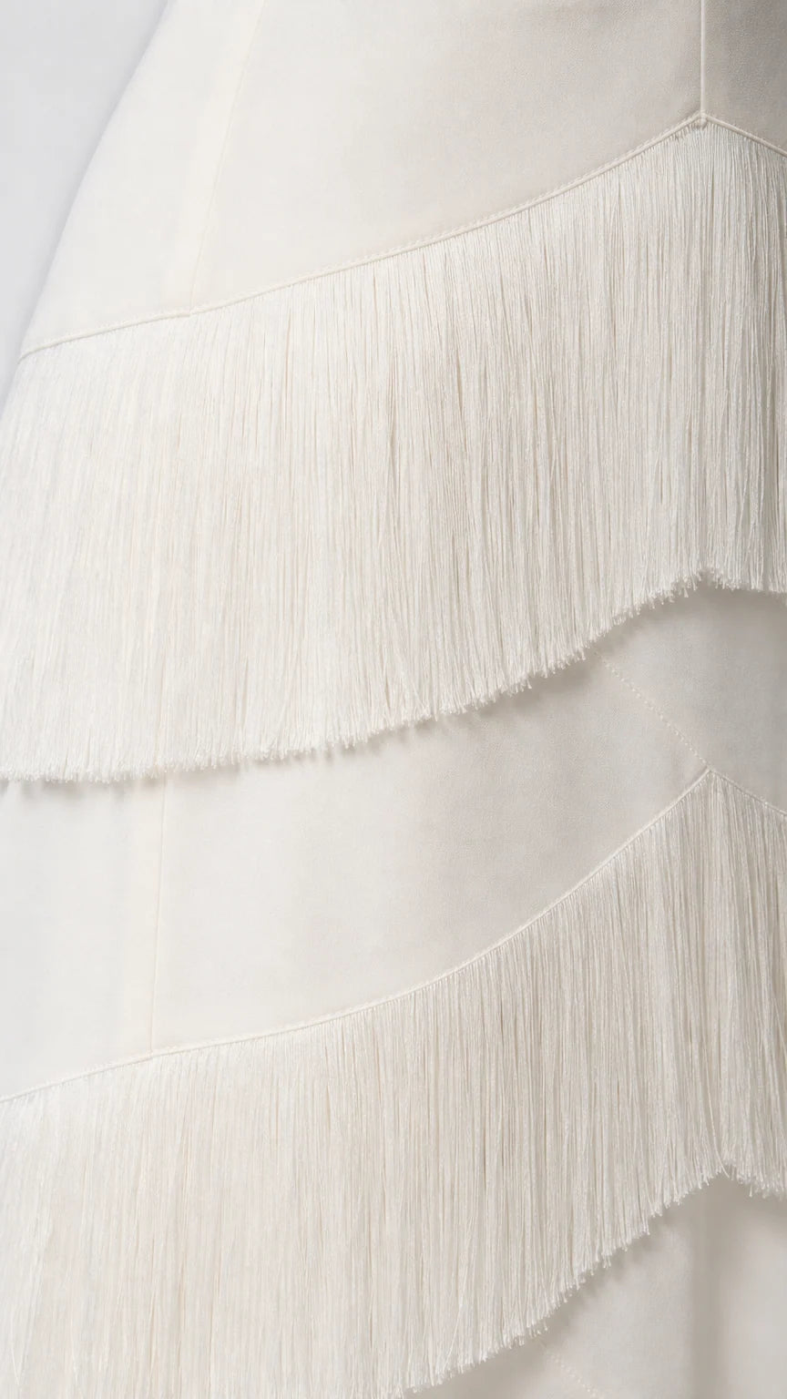 Close-up detail of the fringe texture on the white dress