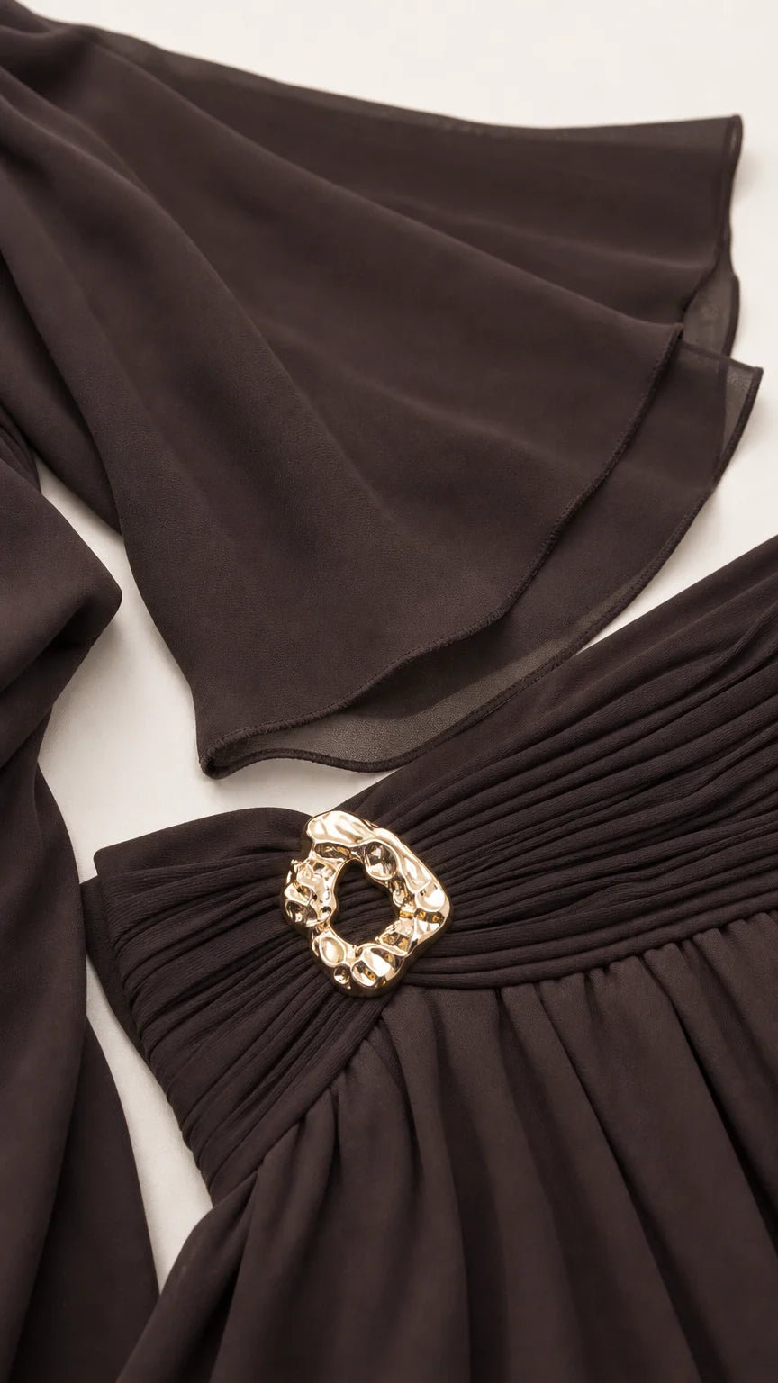 Close-up detail of the wide bell sleeves and ruched waistband with metallic buckle