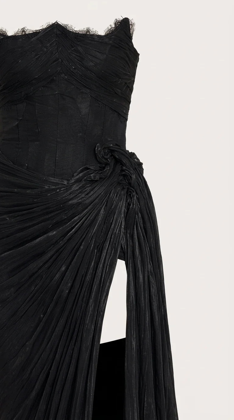 Close-up detail of black corset bodice with scalloped lace neckline and gathered pleats