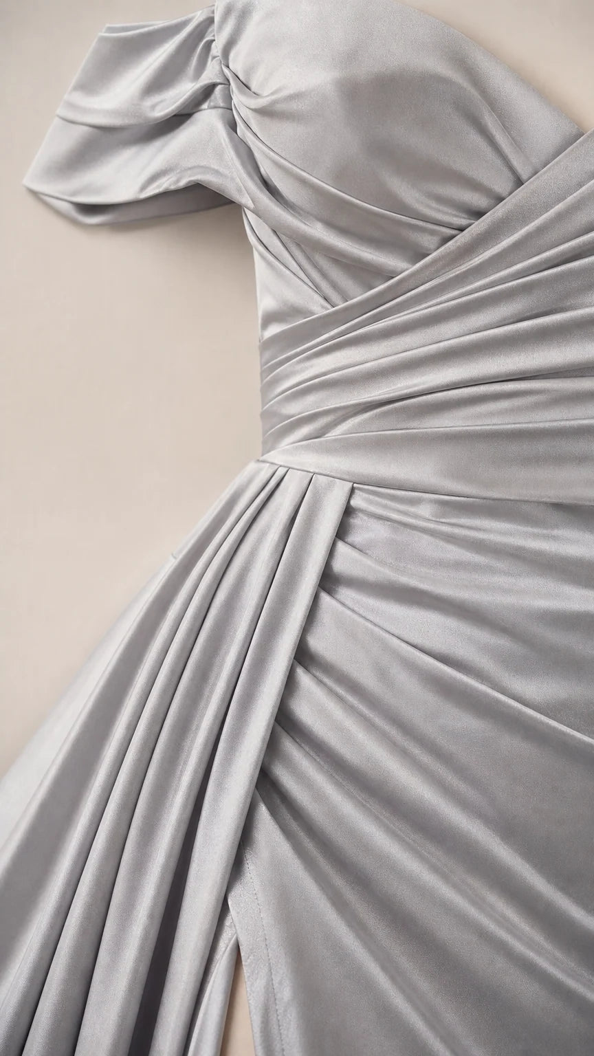 Close-up detail of silver satin fabric draping and diagonal waist ruching