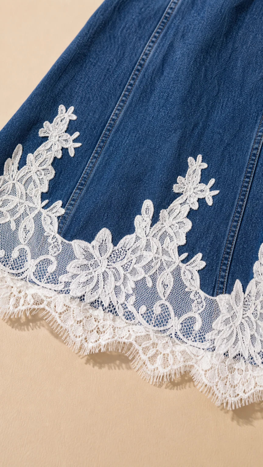 Close-up detail of white scalloped floral lace trim along the denim hemline