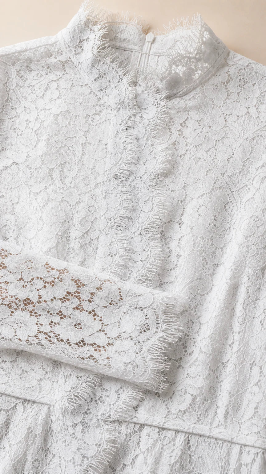 Close up detail of delicate floral lace fabric and mock neckline with eyelash trim